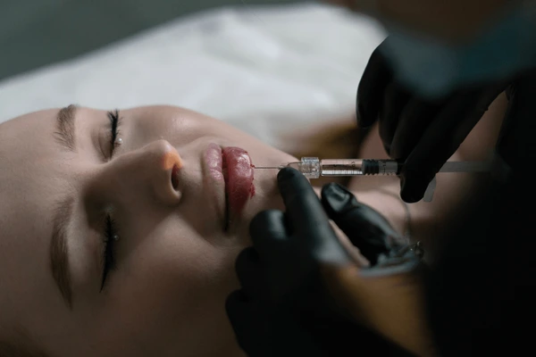 Cosmetologist administering lip injections client welllit 600nw