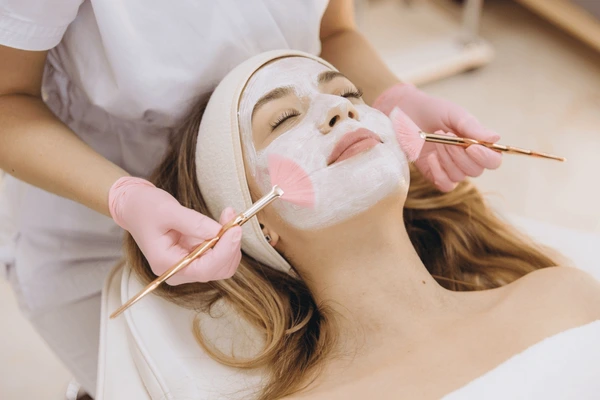 cosmetologist applying facial mask brushes on 600nw 2609992269