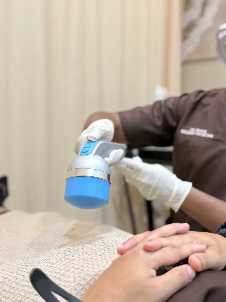 Doctor using a shockwave therapy (ESWT) device applicator at Vivardi Clinics Rawang