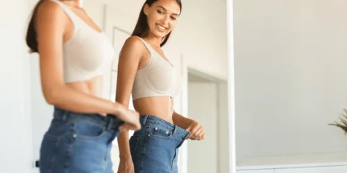 Excited young fit woman losing weight 600nw
