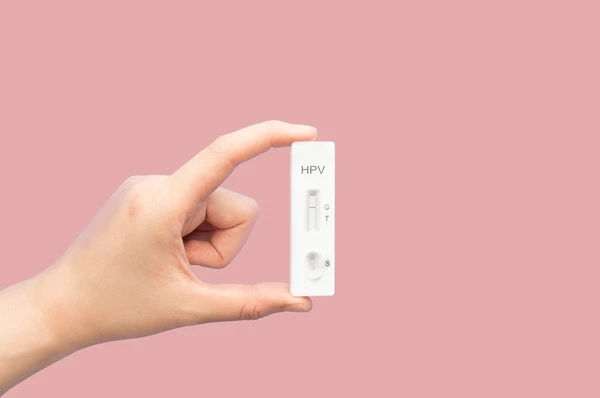Hand holding an HPV test kit