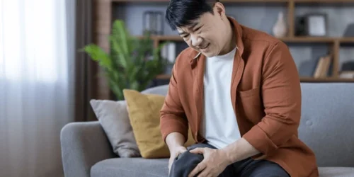 Middleaged asian man sitting on sofa 600nw