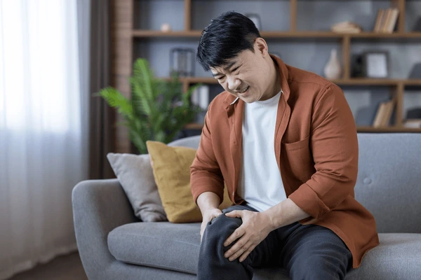 Middleaged asian man sitting on sofa 600nw