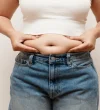 Woman pinching belly fat jeans 600nw
