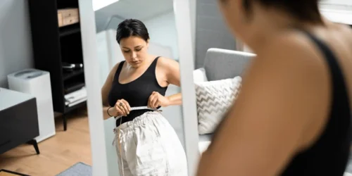Woman weight loss dieting measuring waist 600nw